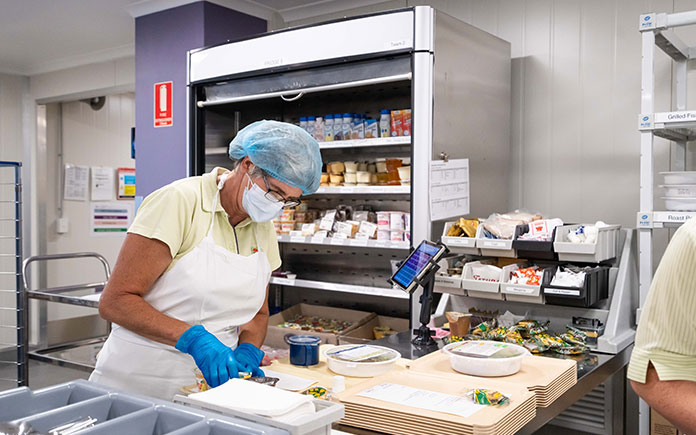 A Food Services staff member preparing fresh, nutritious meals in a NSW public hospital kitchen.